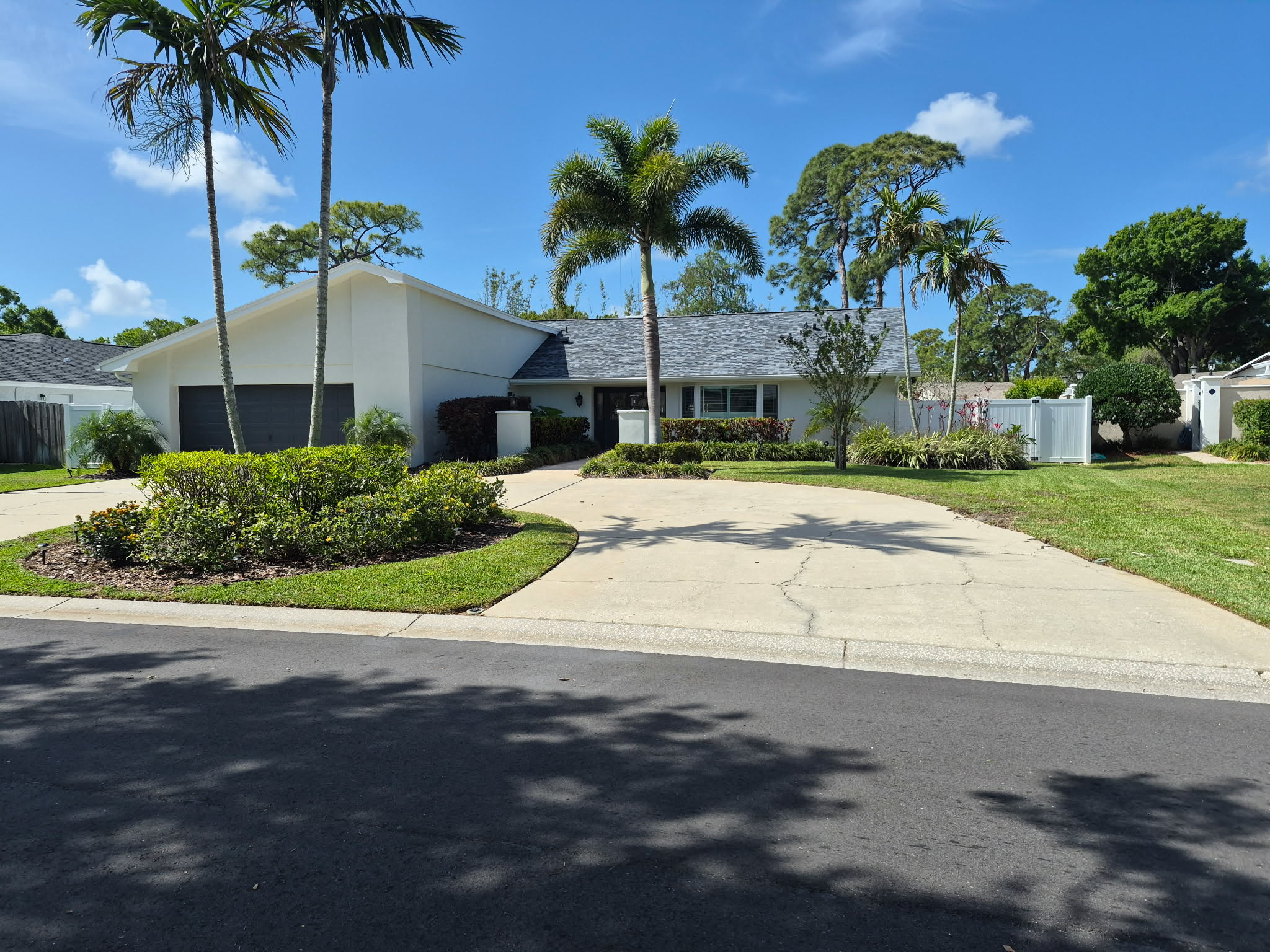 Clean front yard with palm trees and manicured landscaping